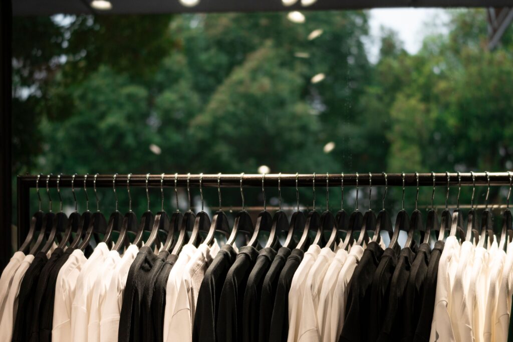 pexels photo 29906028 29906028 A modern clothing display featuring black and white shirts on hangers inside a fashion store.