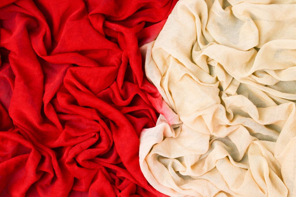 pexels photo 8754132 8754132 Artistic draped red and beige fabric with intricate folds creating a textured appearance.