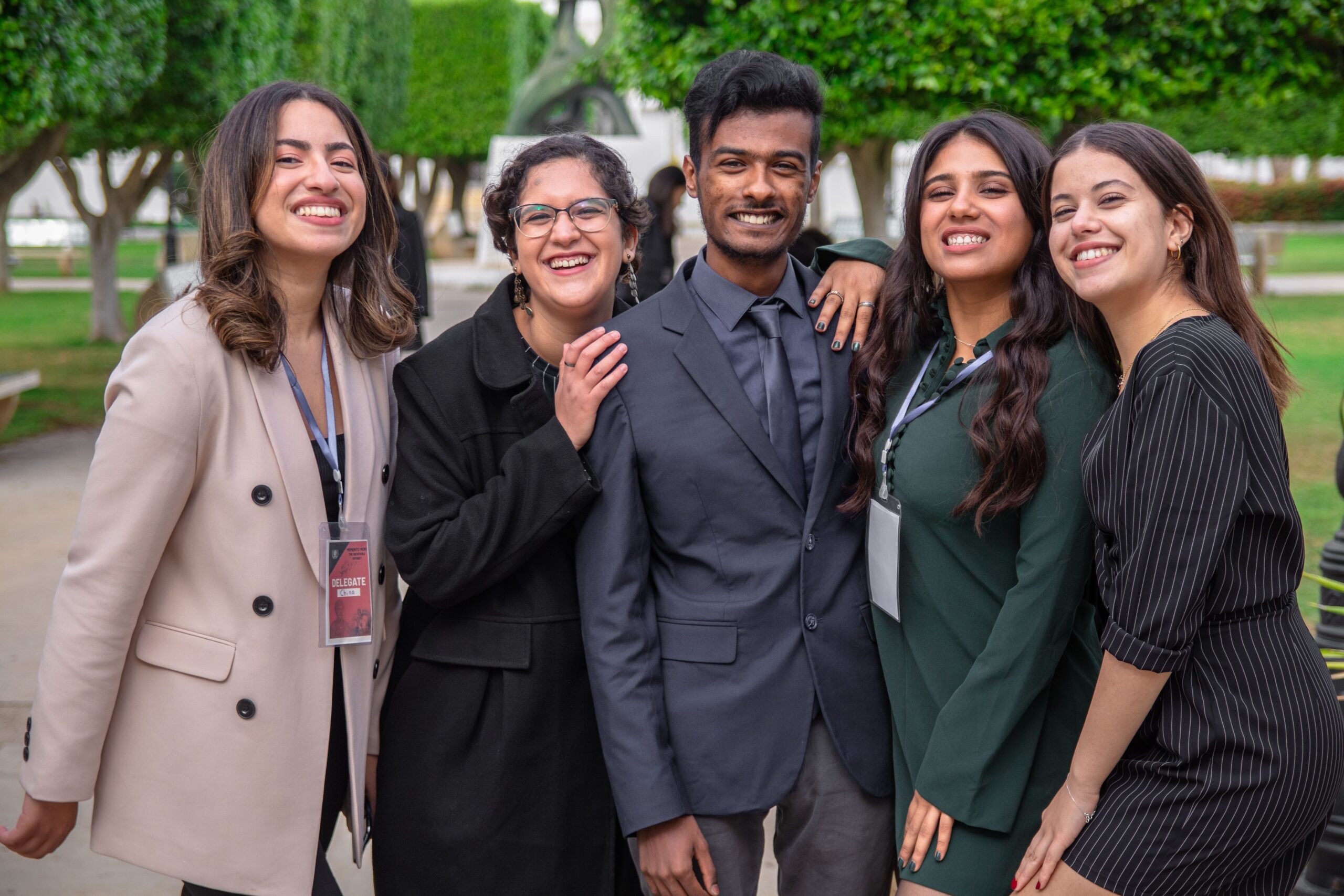 A group of diverse colleagues smiling together, showcasing teamwork and friendship outdoors.